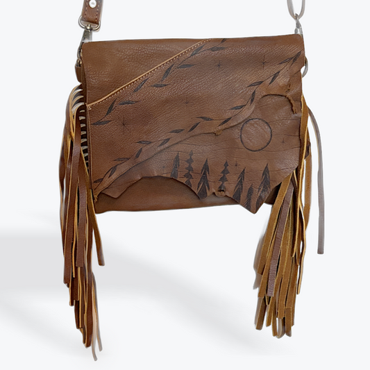 Brown leather bag with fringe and tree design on a white background