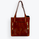Brown leather tote bag with gold zippers on a white background