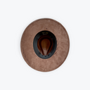 A top-down view of a brown wide-brim hat with a suede-like texture, a dark navy inner band, and a brown cowboy-style hat insert in the center, set against a plain white background.