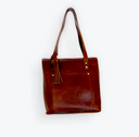Brown leather tote bag with a strap on a white background
